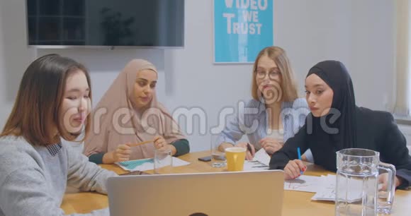 四个自信的不同同事办公室女性头巾讨论业务计划视频的预览图