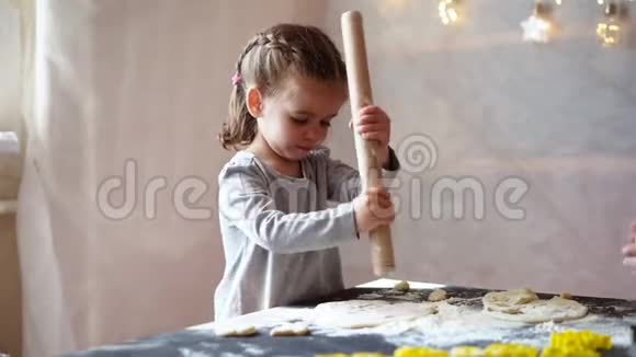 可爱的小白种人女孩3岁准备饼干从生面团在家里视频的预览图