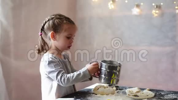 可爱的小白种人女孩3岁准备饼干从生面团在家里视频的预览图