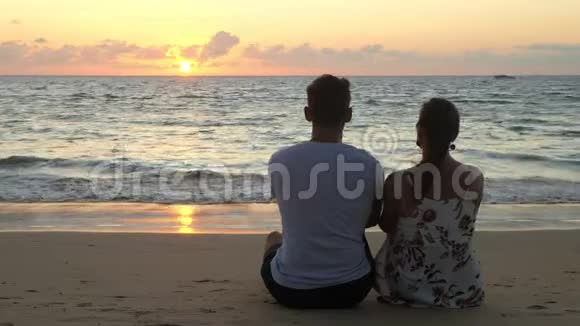 可爱的年轻夫妇坐在海边视频的预览图