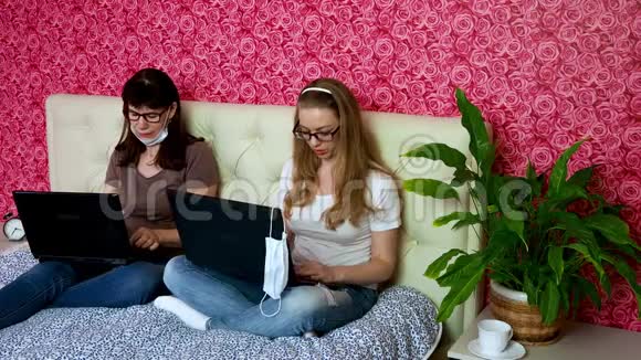 从家里远程工作两名白人女性一名年轻的金发女郎和一名戴防护面罩的成年人正在为一名视频的预览图