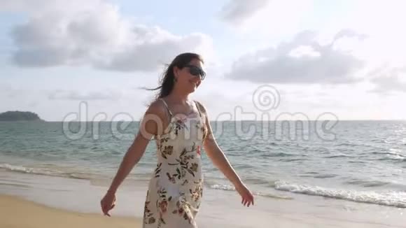 一个快乐的女孩短时间的阳光沿着空海滩散步视频的预览图