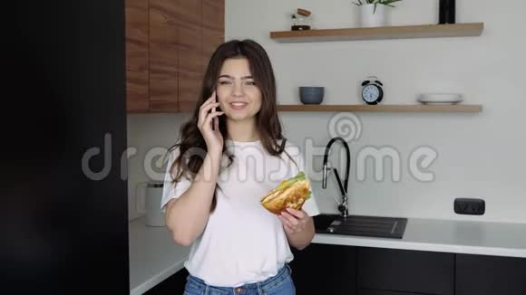 在隔离期间厨房里的女子在智能手机上说话手里拿着三明治情感表达时间视频的预览图