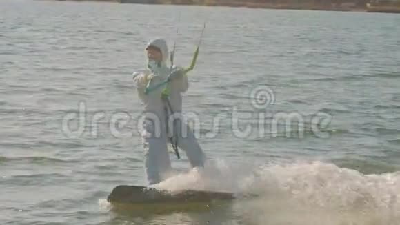 穿着医用个人防护装备的男子在海洋风筝冲浪极限夏季运动慢动作病毒视频的预览图