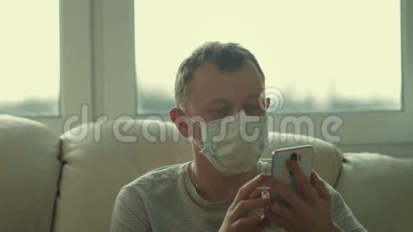 戴着面具的年轻人坐在沙发上用电话视频的预览图