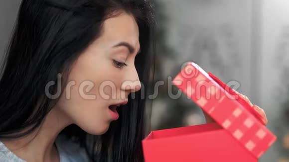 兴奋少女的脸上贴着礼物打开礼盒4K红色相机拍摄视频的预览图