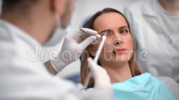 牙医在治疗牙齿前给病人注射牙科注射器4K红色相机拍摄视频的预览图
