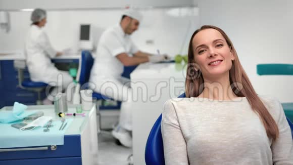肖像美丽的病人妇女摆在牙科扶手椅上中型摄影机视频的预览图