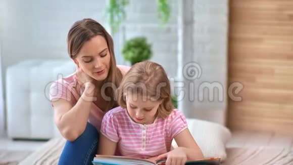 休闲美容妈妈和女孩子在家享受周末阅读教科书中型摄影机视频的预览图