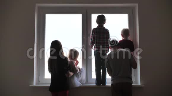 一个大家庭的剪影背景是一个新公寓的窗户隔离概念视频的预览图