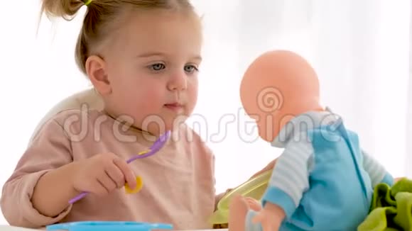 小女孩和娃娃分享食物视频的预览图