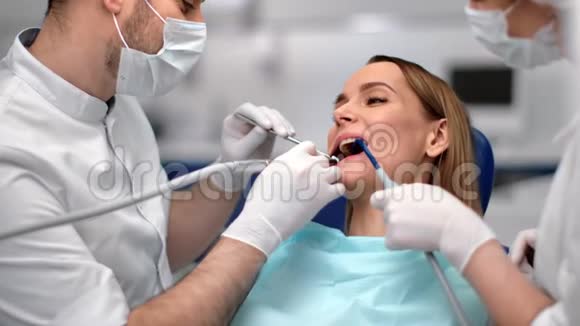 医务人员治疗期间在牙科扶手椅上的女客户中型近距离拍摄4k红色相机视频的预览图