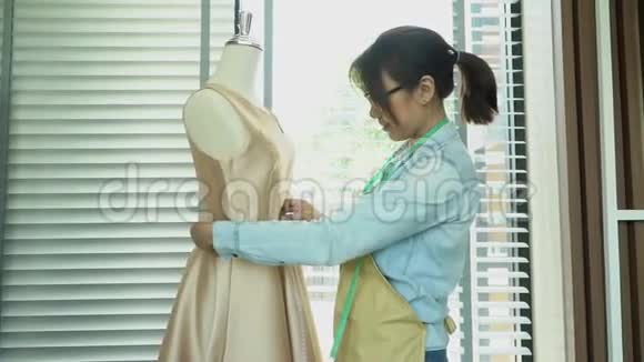亚洲女性时装设计师测量尺寸的人体模型在展厅服装制作和时尚的概念视频的预览图