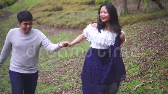 亚洲幸福夫妇一起在热带公园散步牵手视频的预览图