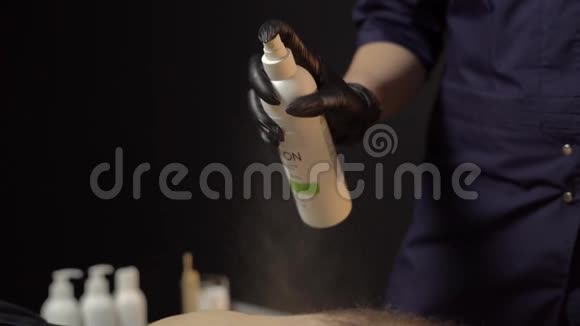 脱毛大师在手术前对男性身体涂上一种特殊的乳液美丽和关爱男性的概念视频的预览图