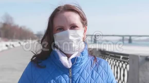 女孩在街上摘下了她的防护面具健康和生命安全的预防和保护冠状病毒视频的预览图