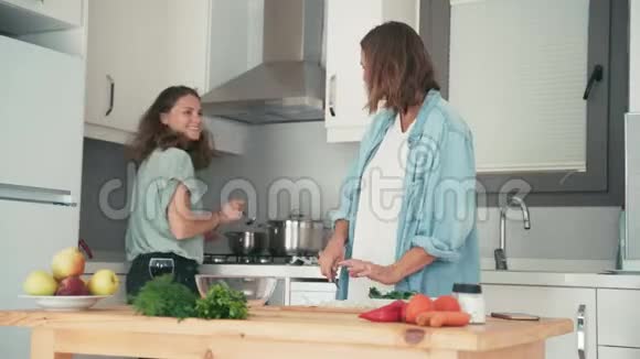 两个年轻漂亮的白种人女人在明亮的厨房做饭视频的预览图
