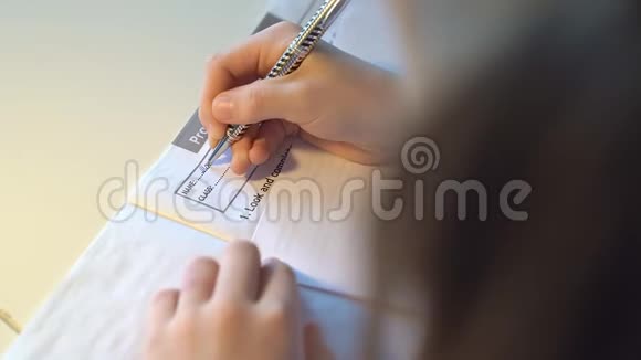 上景手女孩学生在作业本上写字视频的预览图