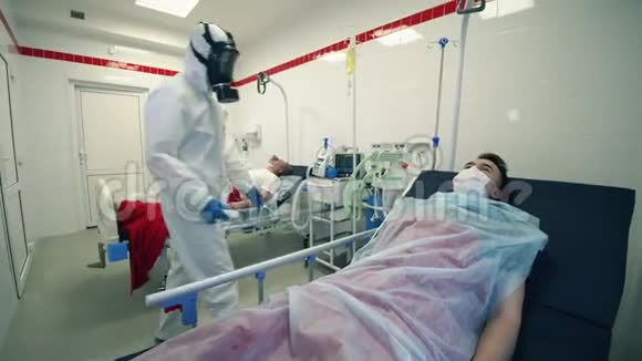 穿防毒服的医生正在检查躺着的病人的体温Covid19大流行病毒冠状病毒疾病视频的预览图