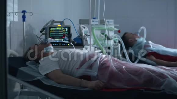 两个人躺在医院里用呼吸机呼吸冠状病毒covid19感染患者在一家诊所视频的预览图