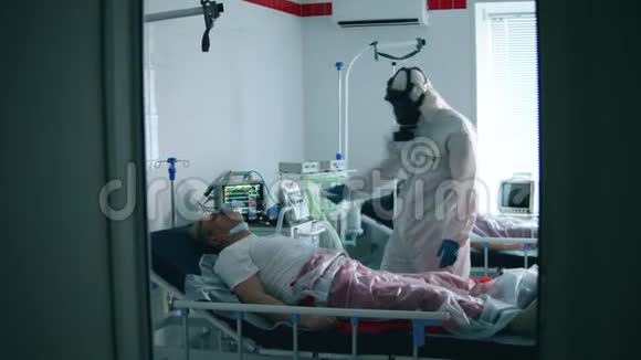 冠状病毒患者附近保护性医生医生正在检查一个戴氧气罩的人的体温视频的预览图