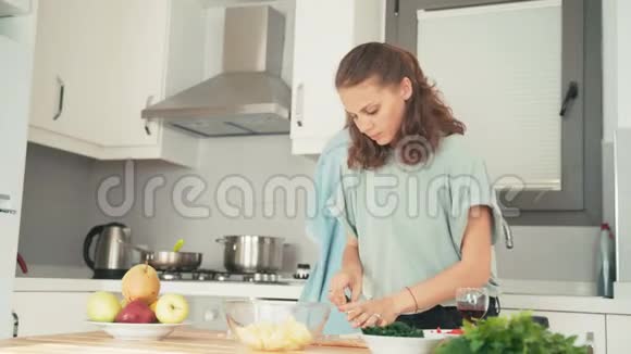 两个年轻漂亮的女人在明亮的厨房里忙着做饭视频的预览图