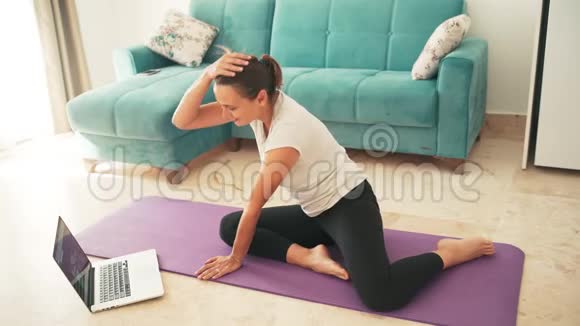 有魅力的年轻女性在家做瑜伽伸展瑜伽视频的预览图