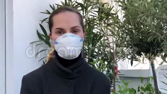戴面具的肖像女子看镜头特写流行性感染冠状病毒4K视频的预览图