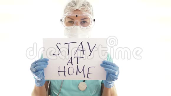年轻的女医生正在家里拿着标签冠状病毒流行视频的预览图