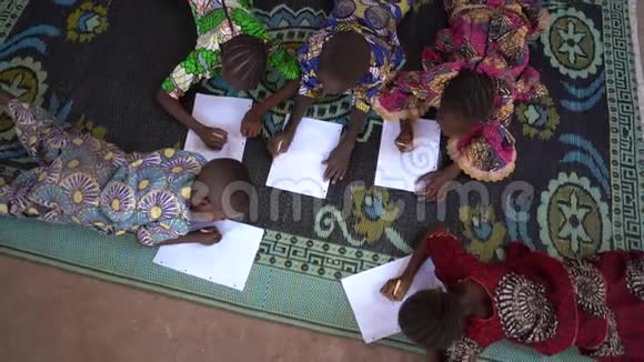 五个小非洲儿童躺在地毯上鸟瞰视频的预览图