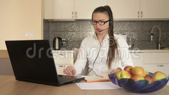 女士带耳机笔记本电脑前的桌子在线咨询远程工作视频的预览图