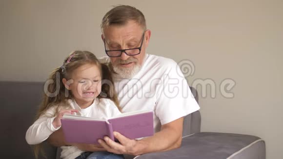 祖父教孙女读书家庭教育观念一位老人和小女孩叶视频的预览图