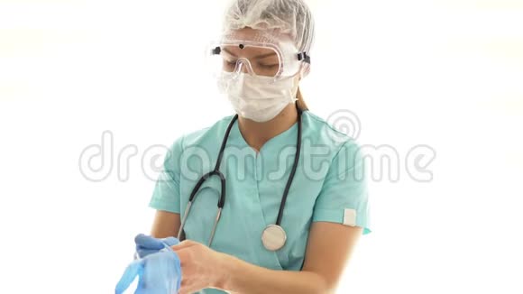 女医生戴着医用口罩和安全眼镜戴上一次性手套医务人员个体防护视频的预览图