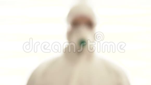 一个穿着防护服和呼吸器的人模糊的身影那人正在靠近用安全眼镜闭上眼睛视频的预览图