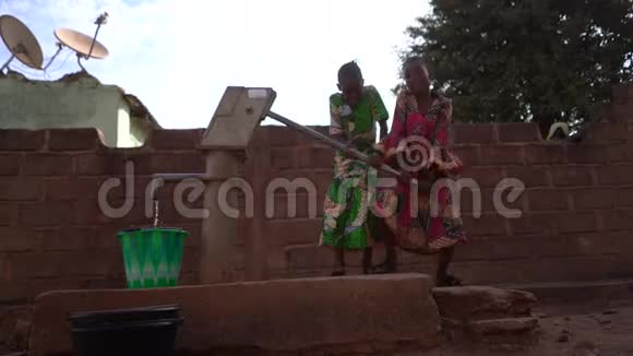 两个快乐的非洲女孩在社区里打水视频的预览图