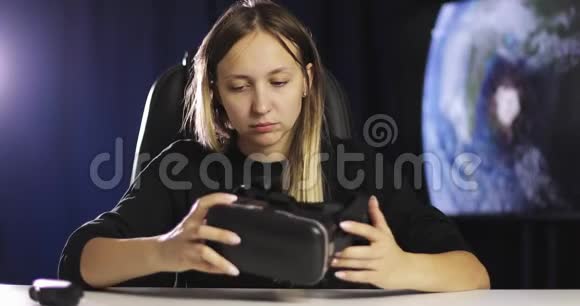 一个女人检查她手中的黑色虚拟现实眼镜视频的预览图