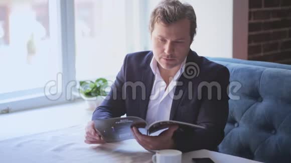 一位英俊的商人坐在桌子旁视频的预览图