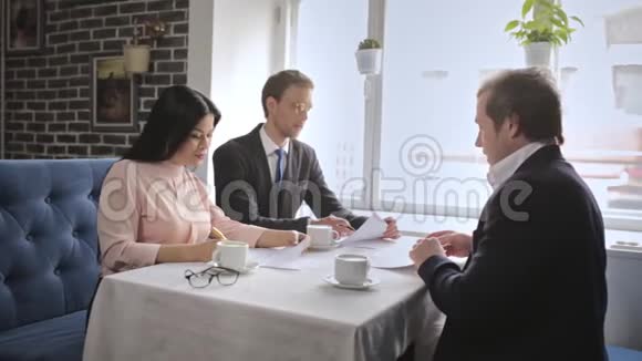 三个自由职业者坐在餐厅签合同视频的预览图