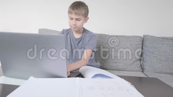 男孩用笔记本电脑学习在家做作业技术远程教育在家在线学习视频的预览图