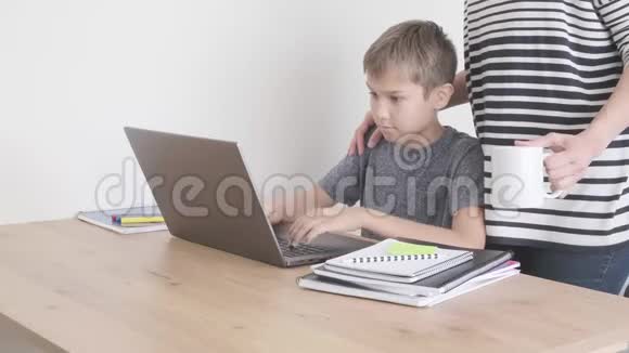 幼儿用笔记本电脑学习在家做作业妈妈来支持他技术远程教育视频的预览图