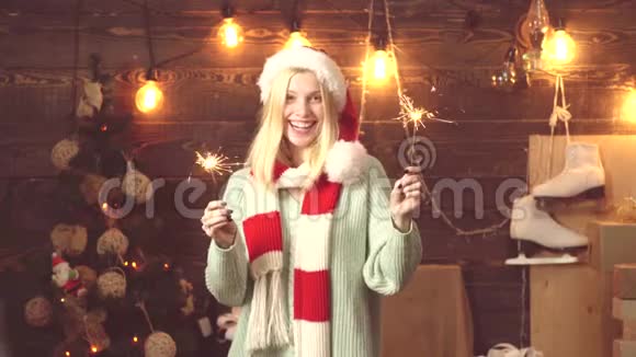 女孩带着真诚的微笑看着镜头摆出燃烧的圣诞火花穿毛衣的金发女郎的肖像视频的预览图