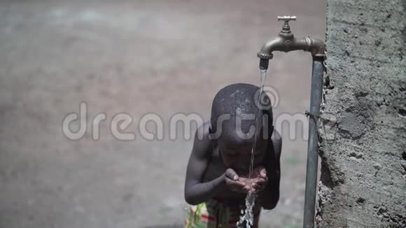 英俊的非洲小男孩在阳光下喝淡水视频的预览图