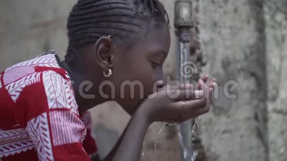 非洲黑人女孩饮用自来水非洲用水安全清洁淡水的肖像视频视频的预览图
