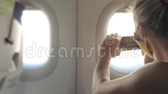 女人在飞机上旅行白种人戴着防护医疗面罩带呼吸器的飞机上的女游客视频的预览图
