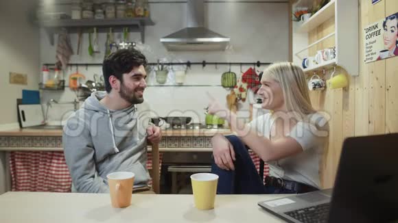 年轻的幸福夫妇在厨房吃早餐时聊天视频的预览图