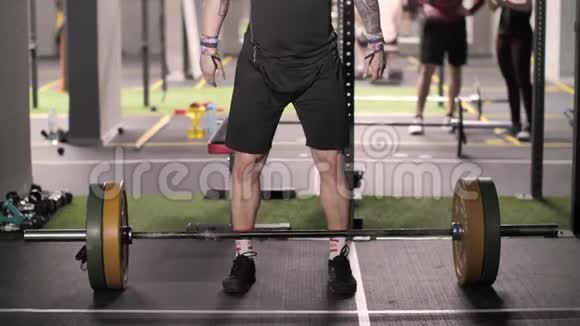 野蛮强壮的男子在健身房用杠铃运动训练做高空举重视频的预览图