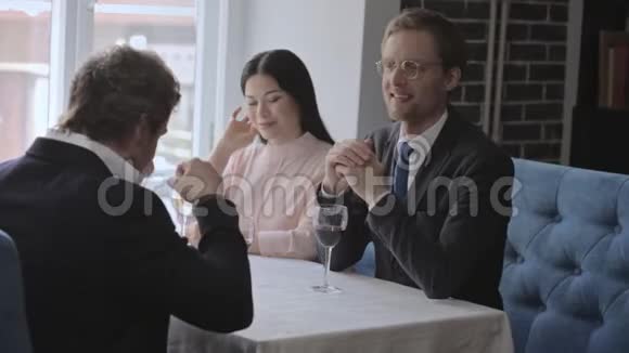 三个商人在一家餐馆吃午饭喝葡萄酒视频的预览图