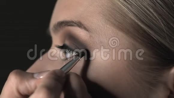 化妆师在美容工作室为年轻女性制作专业化妆的侧视化妆师用刷子视频的预览图