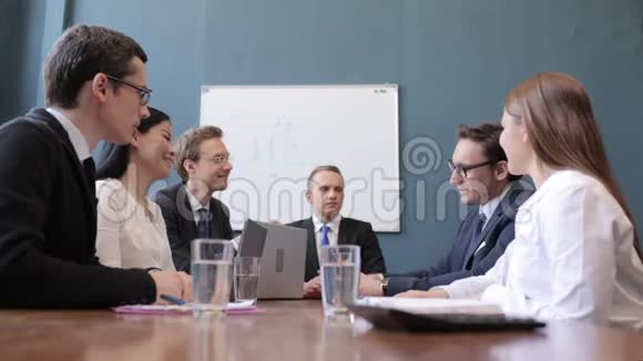 面带微笑的商界人士在与同事坐在一起时表现出色视频的预览图