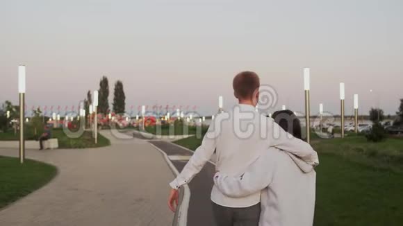 傍晚在夏季公园里年轻可爱的情侣约会后景视频的预览图